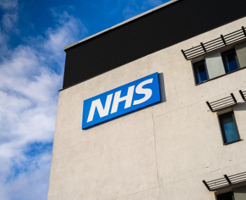 NHS logo as a sign on a building wall