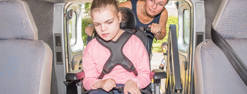 Girl living with spinal cord injury needs a wheelchair in a car