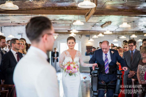 man with spinal injury walking his daughter down the aisle at her wedding 