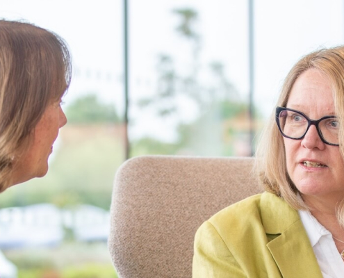 Alison Brooks talking to a colleague - 2 smartly dressed, professional-looking women